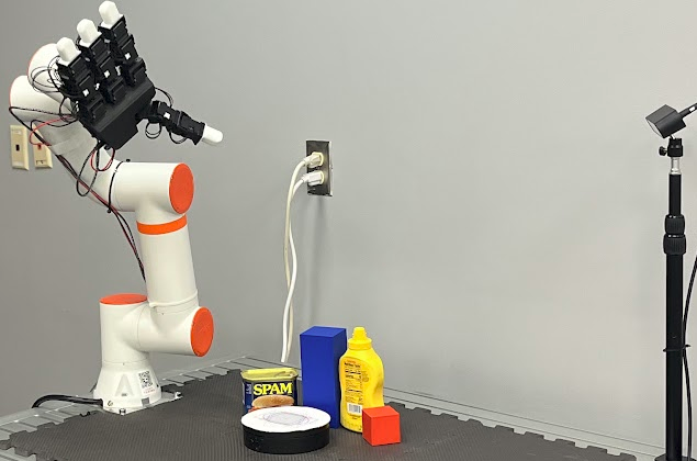 Hardware setup: a LEAP Hand on a 6-DoF ZArm cobot, an object-silhouette-marked pedestal, and a ZED 2i stereo camera on a tripod at right.